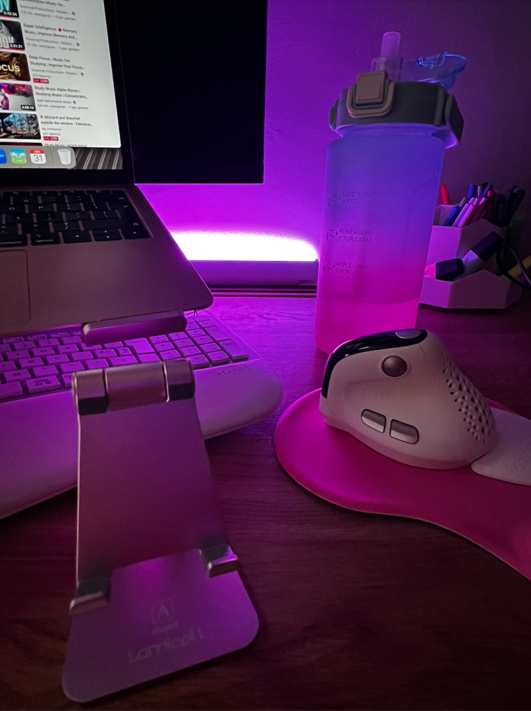 Home office set up met toetsenbord, muis, laptop stand en telefoonhouder.